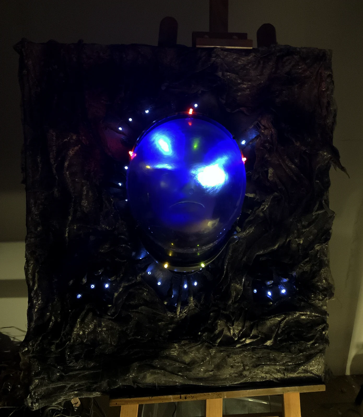 Lost in Space — a luminous blue helmeted face set into a black textured canvas dotted with lights
