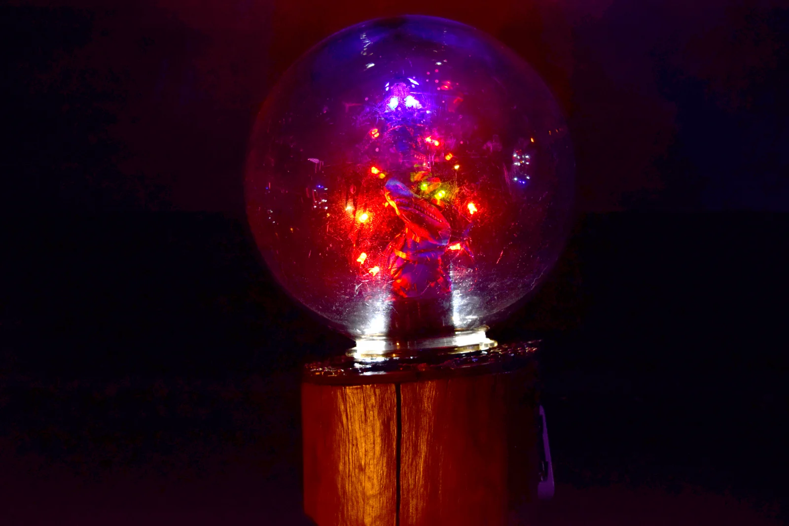 Machinarium — a glass orb glowing red and violet atop a wooden plinth