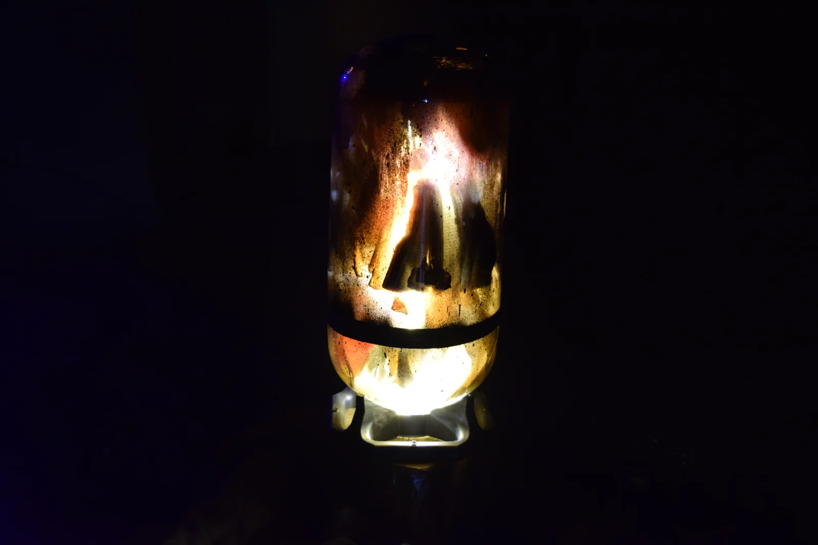 Machinarium — a scorched glass vessel lit from within, hovering in darkness